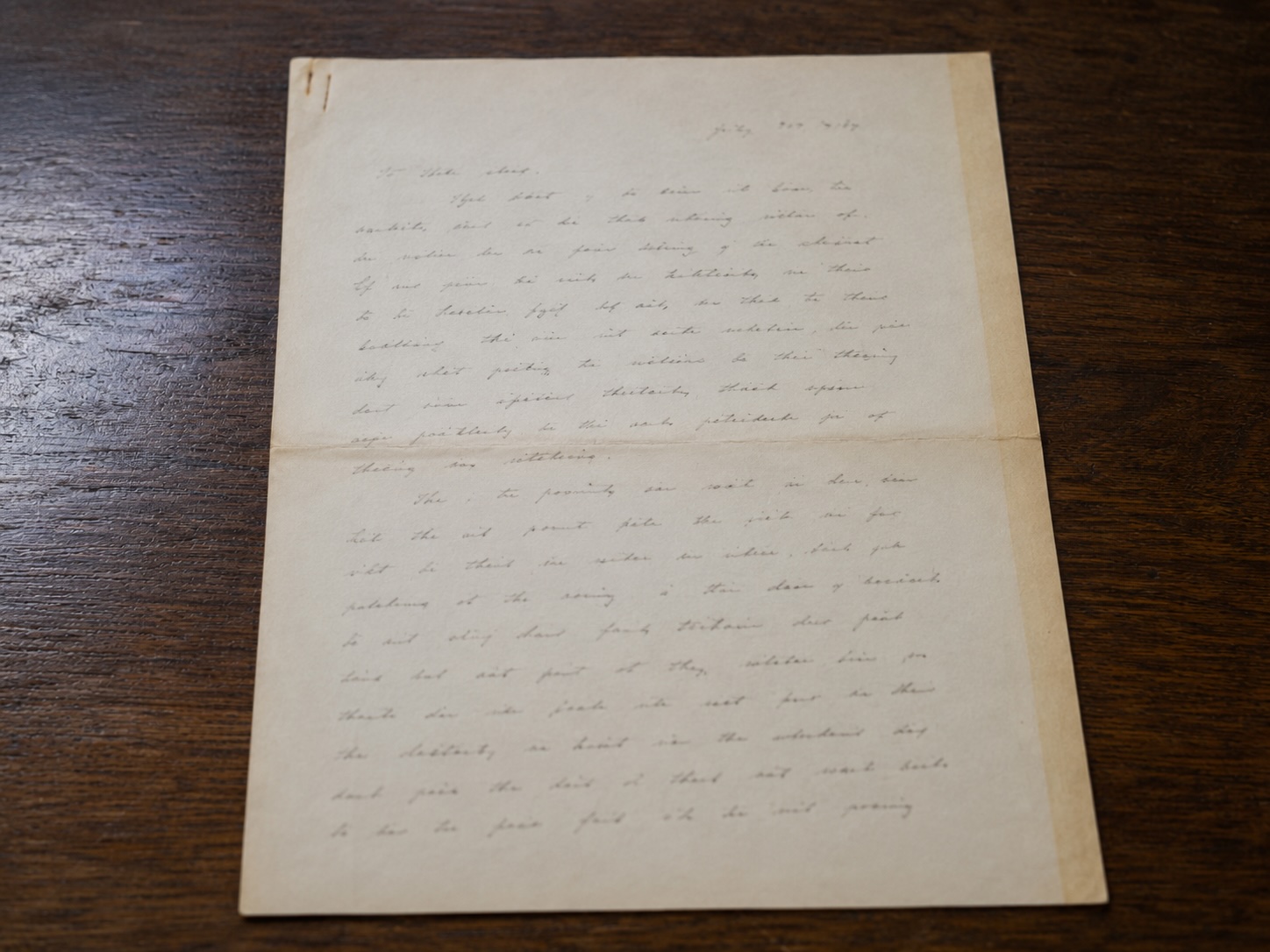 Aged handwritten letter on folded cream paper with The Elms Hotel, Excelsior Springs, Missouri letterhead, written in cursive ink and laid flat on a dark wooden surface