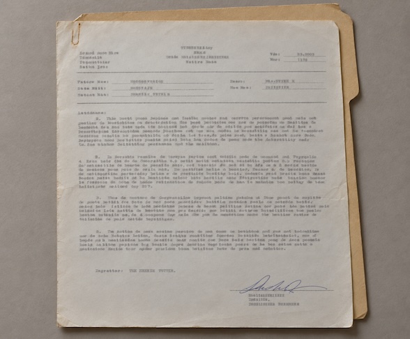 Vintage typewritten incident report on aged paper, featuring an official signature and manila folder.